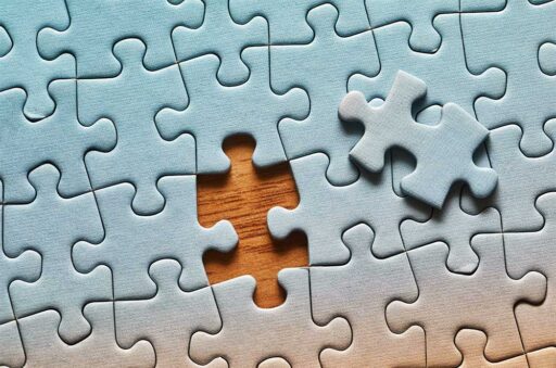Jigsaw puzzle with one piece missing, placed next to the empty space
